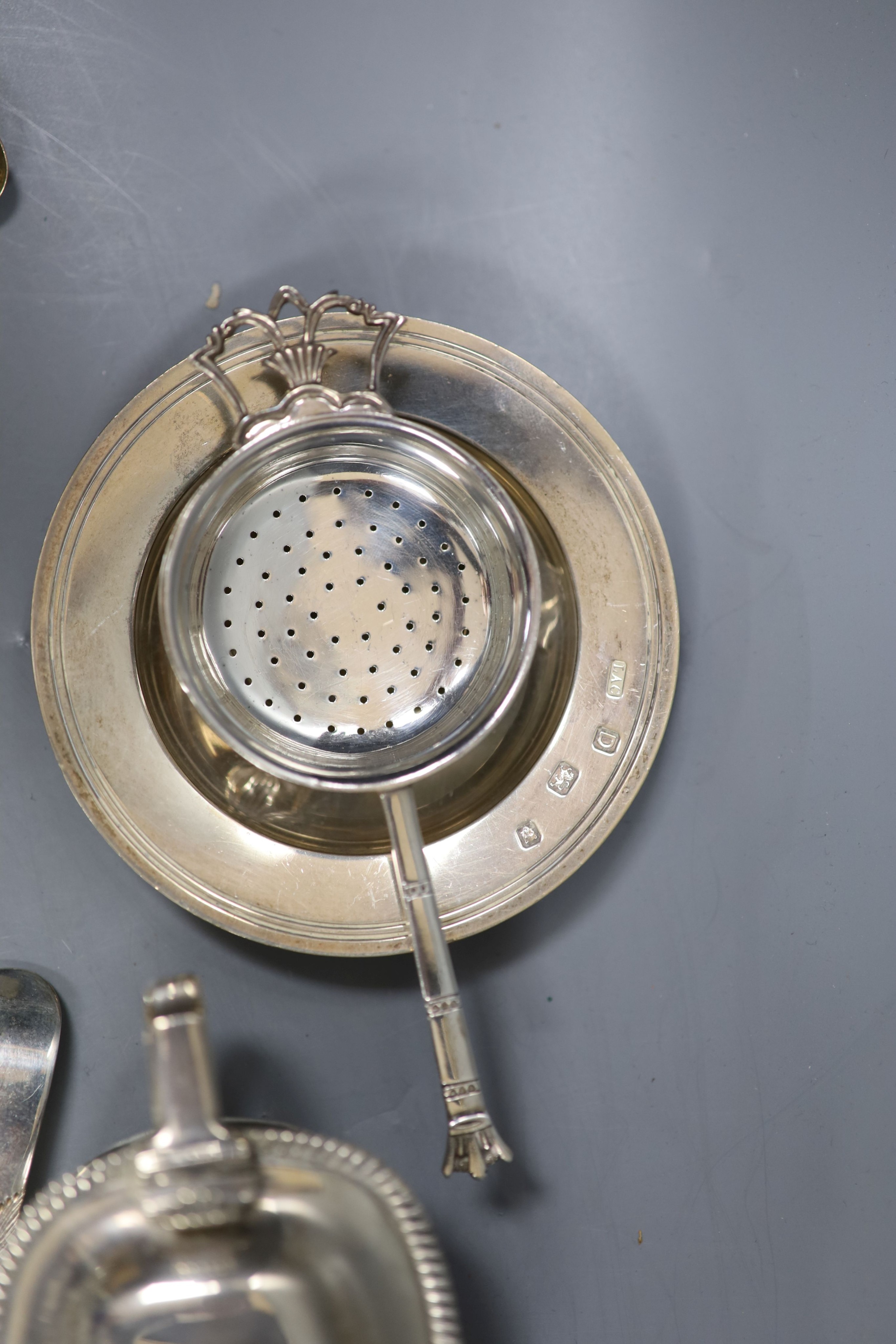 A group of small silver including a Georgian silver mustard, marks rubbed, a pair of Georgian silver berry spoons, two continental spoons, a small Victorian silver cruet stand, a tea strainer on stand, napkin ring, small